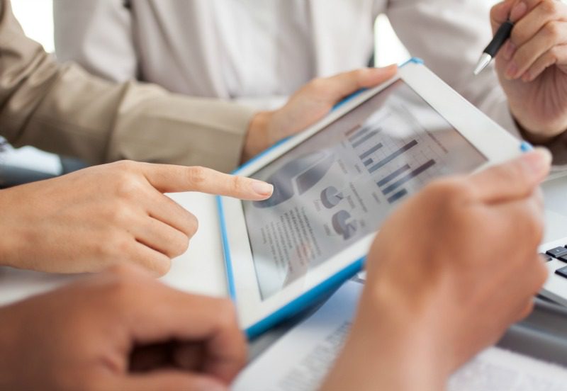 Consultor de negócios analisando números financeiros que denotam o progresso no trabalho da empresa por meio de uma planilha do excel para viagens corporativas