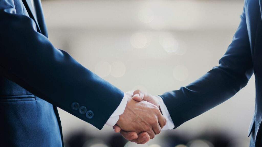 dois homens apertando as mãos após um encontro entre a conversa foi viagens corporativas