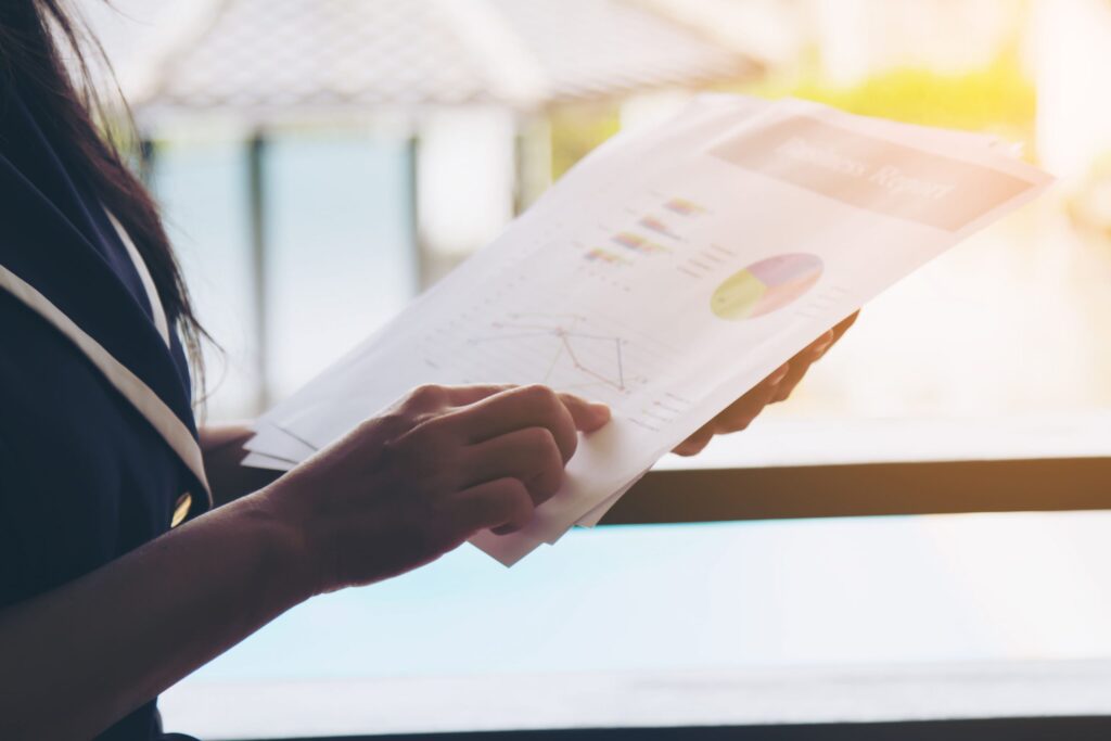 Uma mulher de negócios segura um relatório de viagem enquanto se prepara para compartilhar insights e análises importantes após uma viagem de trabalho bem-sucedida.